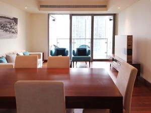 a living room with a large wooden table and chairs at Cinnamon Life Residency in Colombo