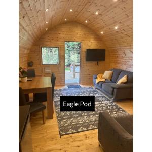 a living room with a couch and a table at Forrester Park Glamping Pods - Eagle Pod and Birdie Pods in Great Totham