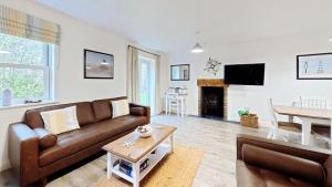 a living room with a couch and a table at Old England Cottage - Part of the The Bay Filey Holiday Village with pool, gym and direct beach access, pub, restaurant, tennis and meadows walks in Filey
