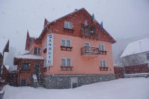 a building in the snow with a sign in front at Anduțu in Buşteni