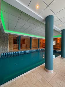 a large swimming pool in a building with columns at Appt 2Pièces-6pers - Balcons de Sirius, Piscine et Sauna in Risoul