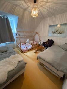 a bedroom with two beds and a baby crib at "1-2-3 SOLEIL" Duplex - 8 pers - La Mongie Pic d'espade in La Mongie
