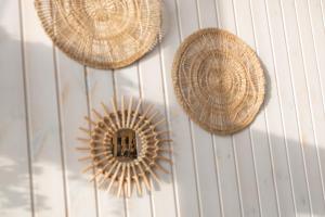 three straw hats are hanging on a wall at Brouwersdam Stay in Ouddorp