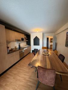 a kitchen and dining room with a wooden table at "1-2-3 SOLEIL" Duplex - 8 pers - La Mongie Pic d'espade in La Mongie