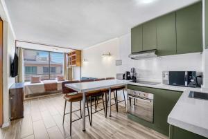 a kitchen with green cabinets and a room with a bed at Espacio Viña- 1D with Wifi in Viña del Mar