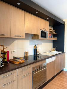 a kitchen with wooden cabinets and a microwave at "1-2-3 SOLEIL" Duplex - 8 pers - La Mongie Pic d'espade in La Mongie +16 photos