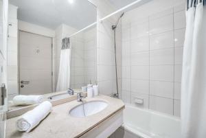 a white bathroom with a sink and a bath tub at Espacio Viña- 1D with Wifi in Viña del Mar +7 photos