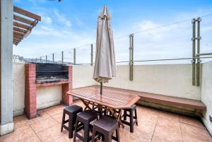 a table and chairs on a balcony with an umbrella at Espacio Viña- 1D with Wifi in Viña del Mar