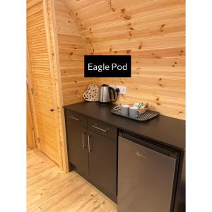 a kitchen with a black counter and a sign that reads eaglepod at Forrester Park Glamping Pods - Eagle Pod and Birdie Pods in Great Totham