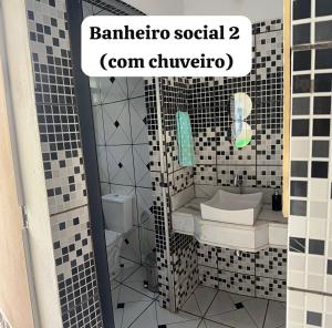 a bathroom with a black and white tiled wall at Casa inteira in Coxim