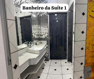 a bathroom with two sinks and a shower at Casa inteira in Coxim +6 photos