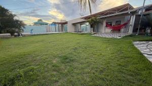 a house with a large yard in front of it at Casa inteira in Coxim