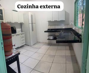 a kitchen with white cabinets and a tiled floor at Casa inteira in Coxim