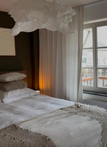 a bed with a white comforter and a window at Boutique appartementen Théodore in Valkenburg