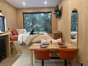 a room with a bed and a table with chairs at Domaine FORESIA in Saint-Alexis-des-Monts