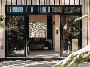 a glass door of a house with a couch at Domaine FORESIA in Saint-Alexis-des-Monts +15 photos