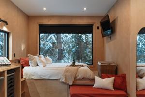a bedroom with two beds and a large window at Domaine FORESIA in Saint-Alexis-des-Monts