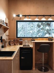 a kitchen with a black sink and a window at Domaine FORESIA in Saint-Alexis-des-Monts