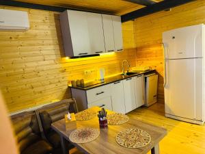 a kitchen with a table and a white refrigerator at Kobuleti Seaside Cottage in Kobuleti +5 photos