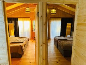 a bedroom with two beds in a log cabin at Kobuleti Seaside Cottage in Kobuleti