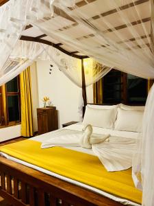 a bedroom with a canopy bed with a stuffed animal on it at Topical Mangrove Villa in Tangalle