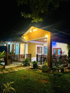a house with a porch at night with lights at Topical Mangrove Villa in Tangalle