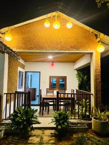 a patio with a table and chairs and lights at Topical Mangrove Villa in Tangalle