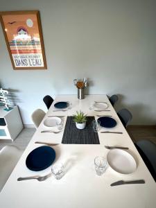 a white table with blue and white plates on it at Maison Aquitaine "Tanchet" in Les Sables-d'Olonne