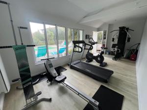 a gym with cardio equipment and a swimming pool at Maison Aquitaine "Tanchet" in Les Sables-d'Olonne