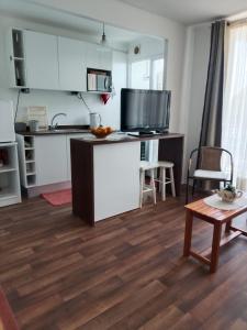 a kitchen with white cabinets and a table in a room at Departamento, Chillan in El Cerrillo