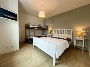 a bedroom with a bed and a bunk bed at Maison Aquitaine "Tanchet" in Les Sables-d'Olonne