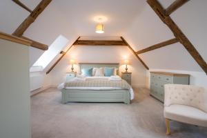 a bedroom with a bed and a chair in a attic at Ploughman’s Green, Blythburgh in Halesworth