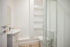 a bathroom with a toilet and a glass shower at Ploughman’s Green, Blythburgh in Halesworth +28 photos