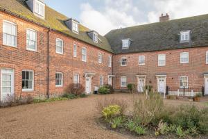 a large brick building with white doors and windows at Ploughman’s Green, Blythburgh in Halesworth