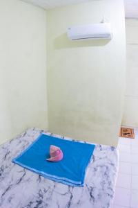 a pink hat sitting on top of a blue towel at Wisma Dahlia in Maumere