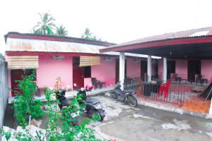 a pink house with motorcycles parked outside of it at Wisma Dahlia in Maumere