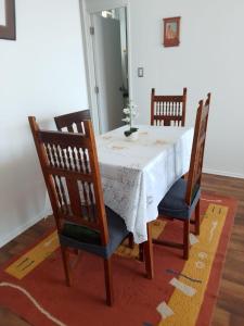 a dining room table with two chairs and a white table cloth at Departamento, Chillan in El Cerrillo +7 photos