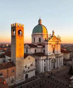 eine Kirche mit einem Glockenturm und einem Gebäude in der Unterkunft Capitolium Ad in Brescia