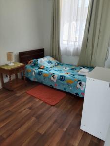 a small bedroom with a bed and a table at Departamento, Chillan in El Cerrillo