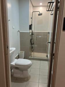 a bathroom with a toilet and a glass shower at SMDC Cheer residences-ZKL SUITES in Marilao