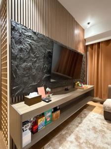 a living room with a large flat screen tv on a wall at SMDC Cheer residences-ZKL SUITES in Marilao