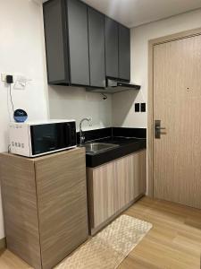 a kitchen with a microwave and a sink and a door at SMDC Cheer residences-ZKL SUITES in Marilao +4 photos