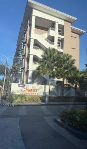 a large building with palm trees in front of it at SMDC Cheer residences-ZKL SUITES in Marilao