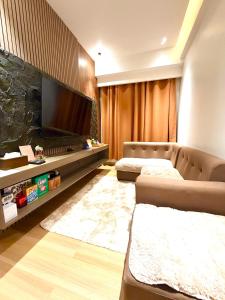 a living room with two couches and a flat screen tv at SMDC Cheer residences-ZKL SUITES in Marilao