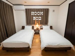 two beds in a room with a sign on the window at MEME Villa 5BR - 3 Separate Toilets & 3 Showers - 10Gbps Wifi in Tokyo