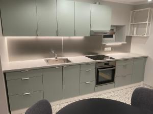 a kitchen with white cabinets and a sink at "Pas draugą" Šalkauskio g in Kaunas