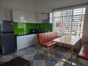 a kitchen with a table and chairs and a refrigerator at THHomestay in Danang