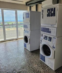 two washing machines stacked on top of each other in a building at Condomínio Residencial - Hype 017 | by Housi in Sao Jose do Rio Preto