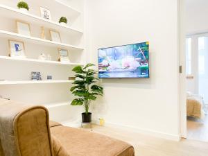 a living room with a tv hanging on a wall at Modern 3 Bedroom Apartment Near Belém Lisbon Upto 5 Guests in Cruz Quebrada