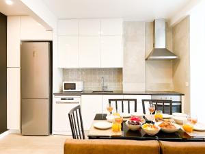 a kitchen with a table with bowls of food on it at Modern 3 Bedroom Apartment Near Belém Lisbon Upto 5 Guests in Cruz Quebrada +11 photos